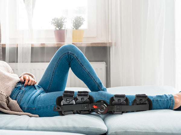 The_woman_wearing_a_hinged_ROM_knee_brace_lay_on_the_bed